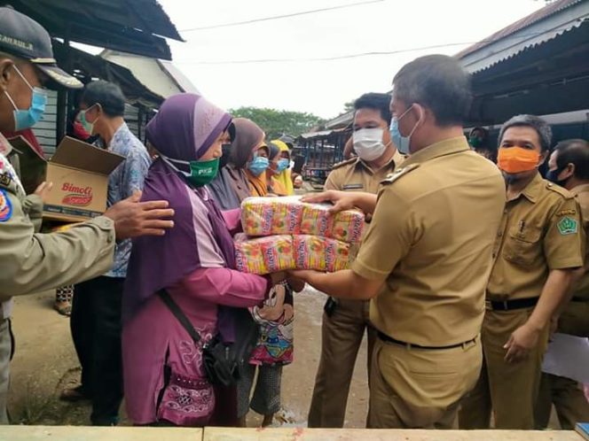 
					Wakil Bupati Konawe Gusli Topan Sabara didampingi Kadis Perindakop Konawe Jahiuddin dan sekretarisnya Sadeli saat membagikan sembako di pasaran sentral Asinua. Foto Dedy . SH.